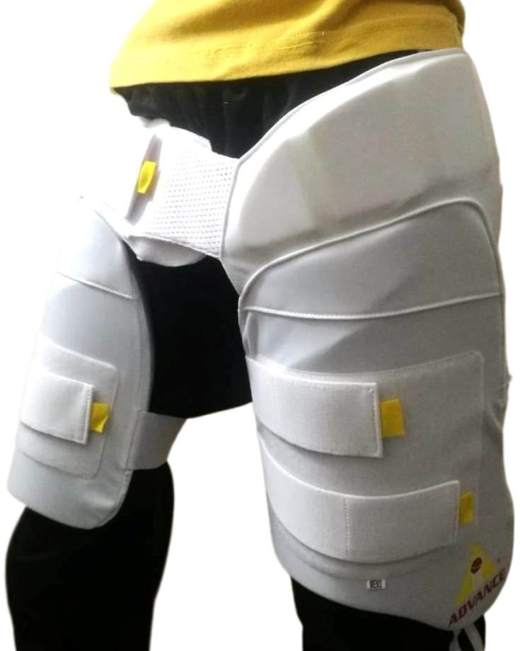 A cricket enthusiast wearing a yellow shirt is shown from the waist to mid-thigh level. They are sporting Advance P1 white, padded cricket leg guards with straps and yellow accents for impact protection from the brand Advance. The background is plain white.