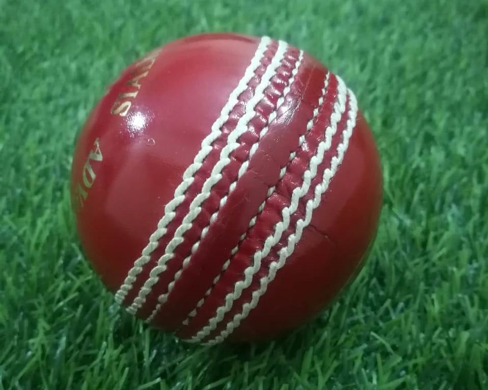 A red leather cricket ball from the "Advance Target 300 - 156g Red - Pack of 6 Balls" collection is featured against a plain white background, showcasing its prominent white hand-stitching. The ball boasts the brand name "ADVANCE" engraved in gold letters on one side, emphasizing its premium quality.