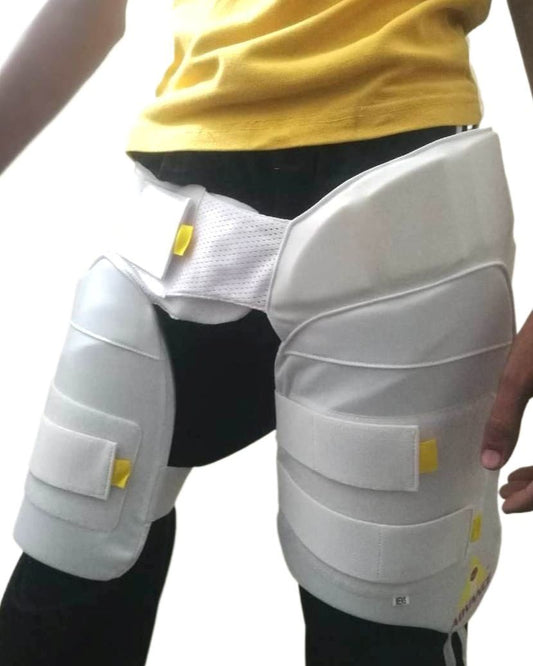 A cricket enthusiast wearing a yellow shirt is shown from the waist to mid-thigh level. They are sporting Advance P1 white, padded cricket leg guards with straps and yellow accents for impact protection from the brand Advance. The background is plain white.